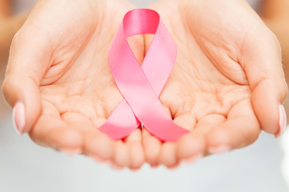 Due mani aperte contengono un fiocco rosa.