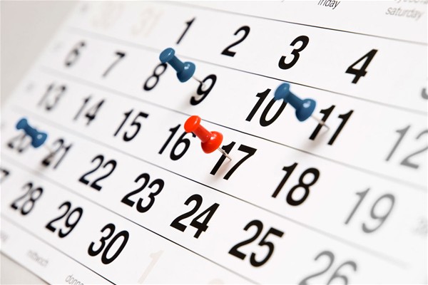 Un calendario mensile con alcune date evidenziate da una puntina blu ed una da una puntina rossa.